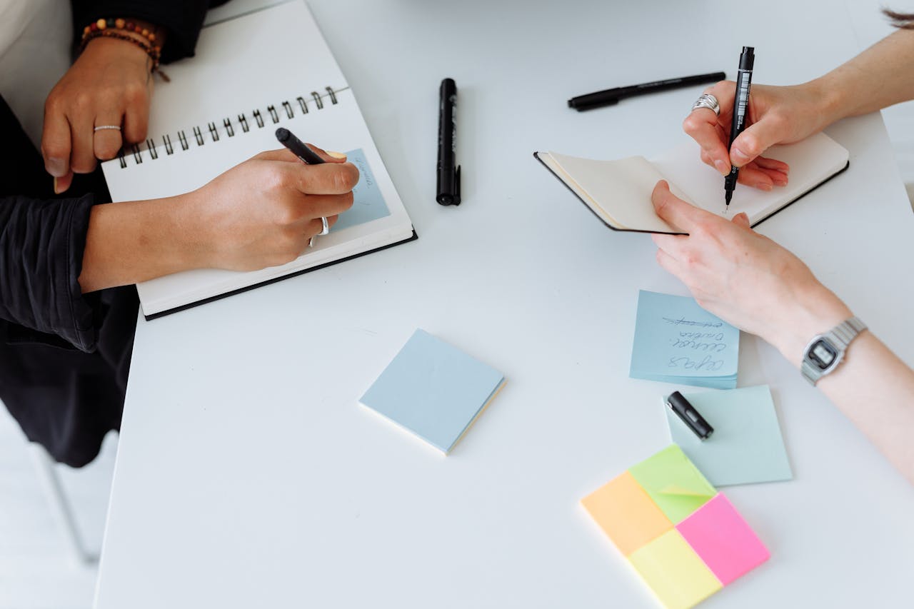 Persone alla scrivania scrivono su post-it